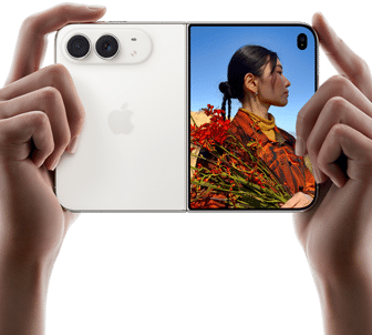 iPhone Duo, Star White color, held by two hands in horizontal orientation, unfolded, left panel shows 48MP Dual Fusion rear cameras, right panel shows person getting their picture taken on outer display, the subject of the photo is able to see their face as their picture is getting taken using Duo Preview